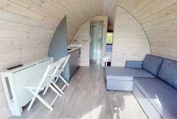 Ensuite glamping pod interior with sofa bed and dining space (fold away table)