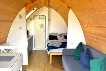 Glamping pod interior with double bed, sofa bed and kitchenette Glamping pod interior with double bed, sofa bed and kitchenette