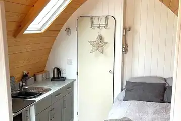 Glamping pod interior with double bed, kitchen and ensuite Glamping pod interior with double bed, kitchen and ensuite