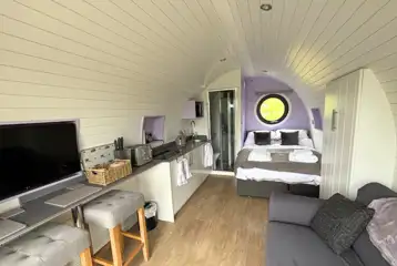 Glamping pod interior with a double bed and double sofa bed
