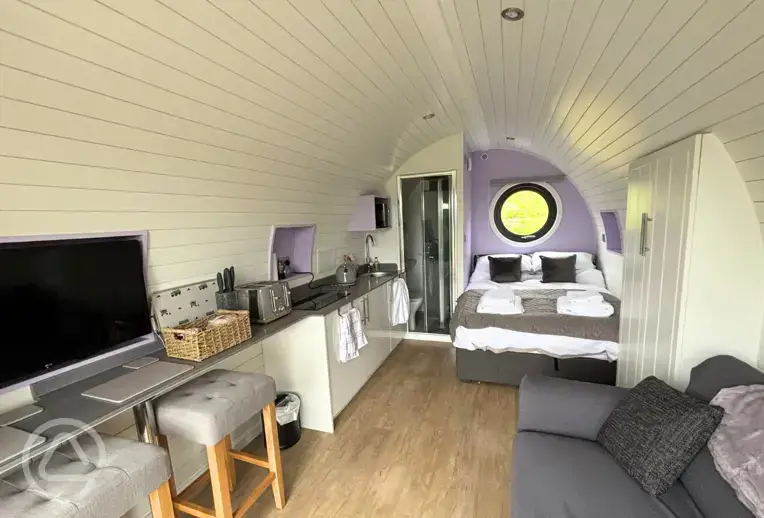 Glamping pod interior with a double bed and double sofa bed