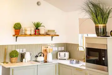 Cabin kitchen with a fridge/freezer, microwave, kettle, hob, sink and toaster