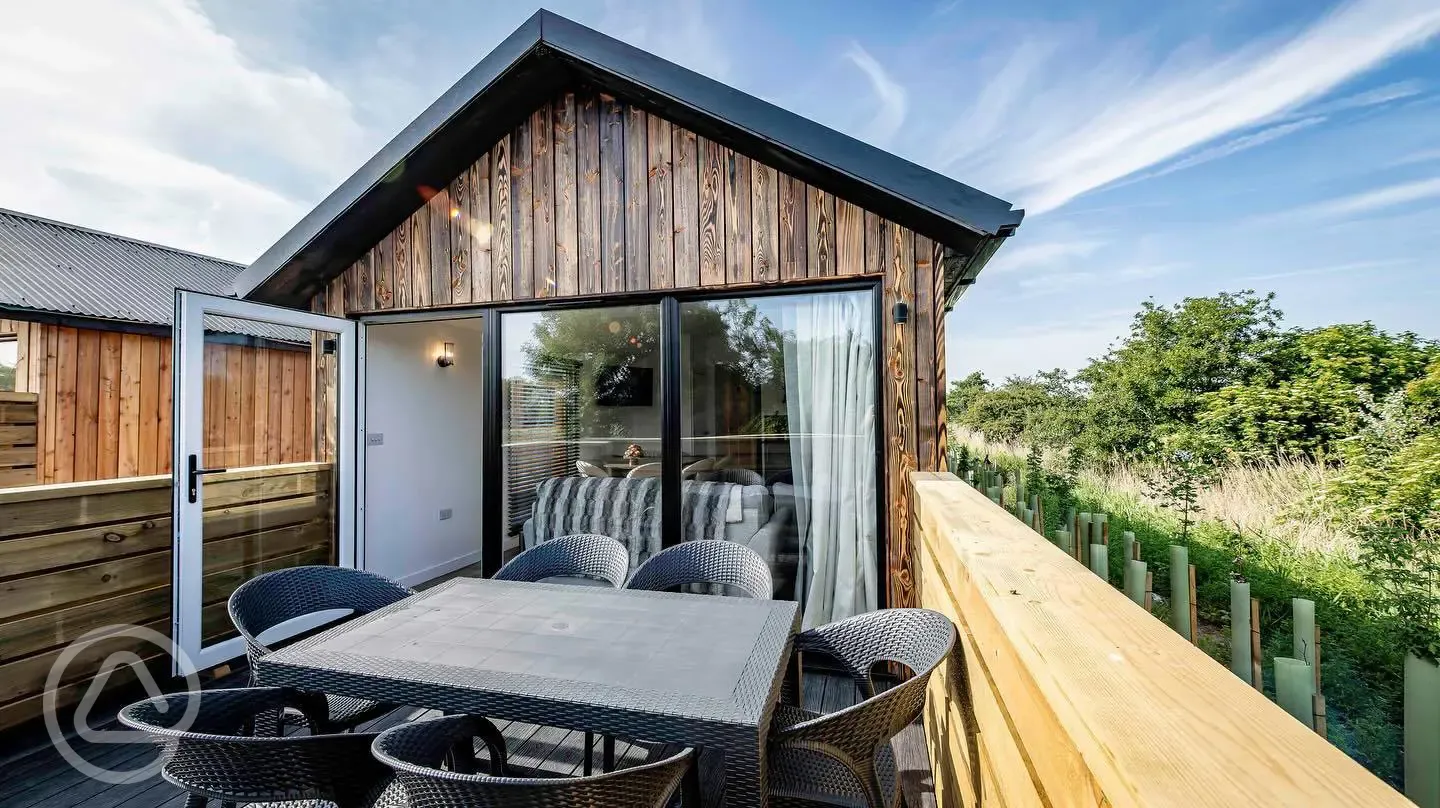 Cabin with glass doors and a private outdoor decking with seating
