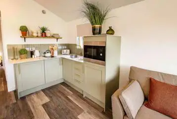 Cabin kitchen with a fridge/freezer, microwave, kettle, hob, sink and toaster