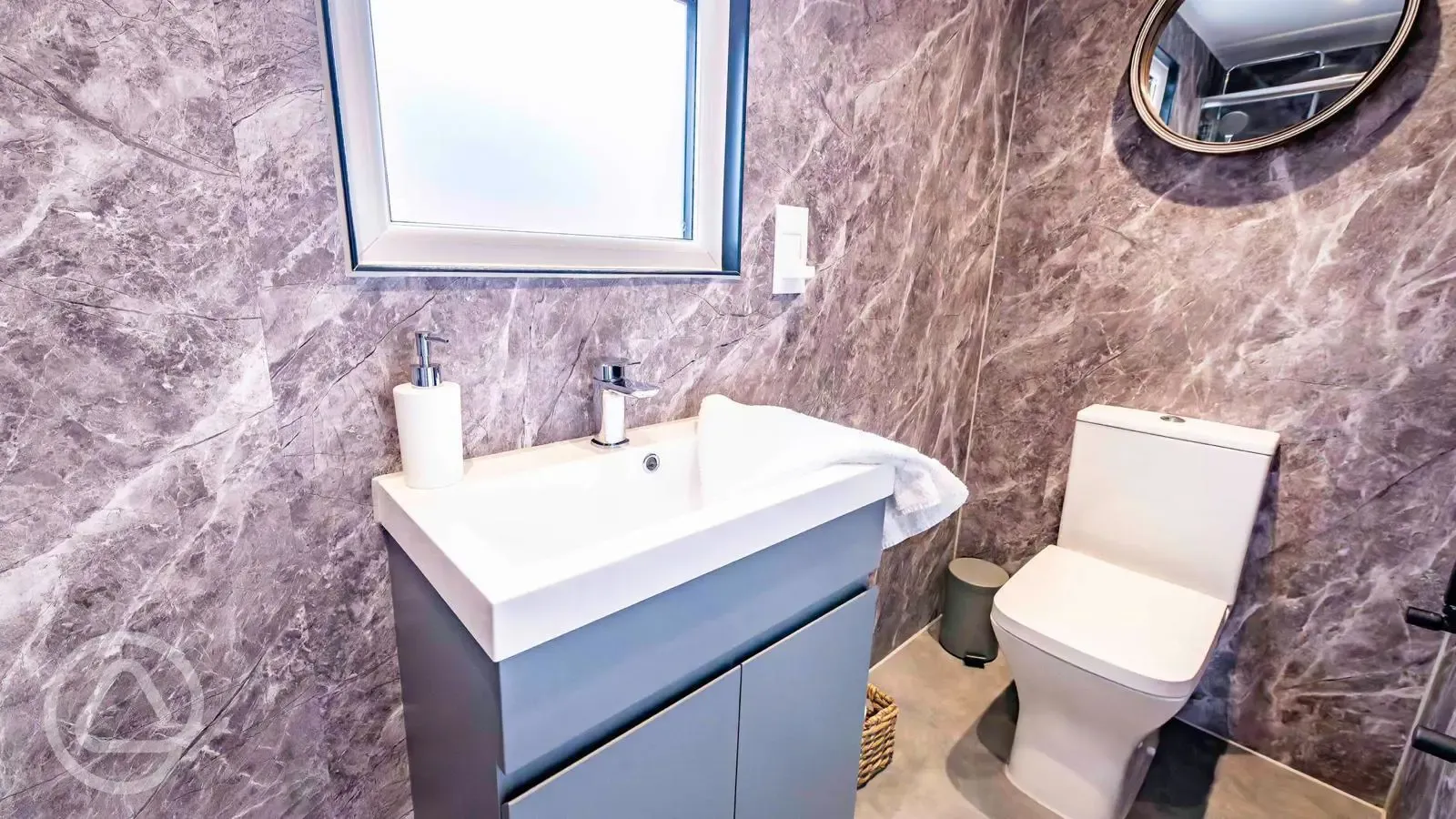 Cabin ensuite bathroom with toilet, hand basin, shower and towels
