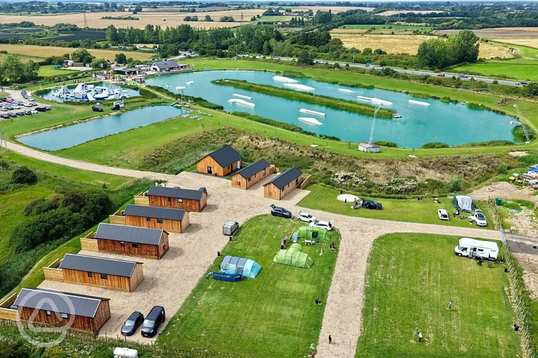 Aerial view of grass pitches, ensuite cabins and aqua park at Whitemills Wake