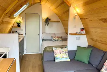 Glamping pod interior with a double bed, double sofa bed and kitchenette Glamping pod interior with a double bed, double sofa bed and kitchenette