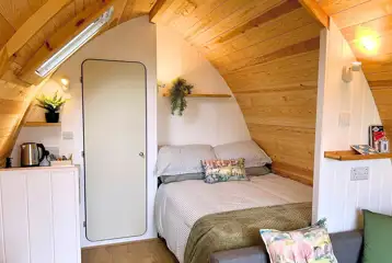Glamping pod interior with a double bed with bedding provided Glamping pod interior with a double bed with bedding provided