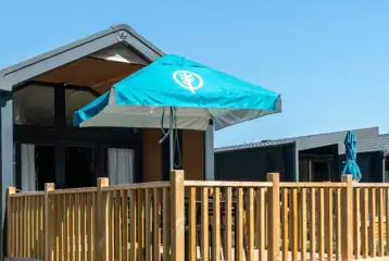 Superior glamping cabins with an outdoor deck, furniture and parasol