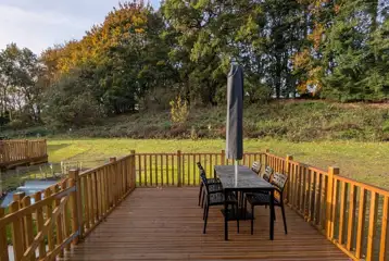 Superior glamping cabins with an outdoor deck, furniture and parasol