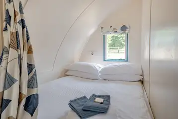 The Wonneys pod with a king bed and privacy curtain