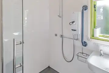 Humbleton accessible wet room with grab rails and a shower chair