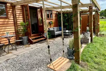 Willow glamping lodge outdoor area and swing Willow glamping lodge outdoor area and swing