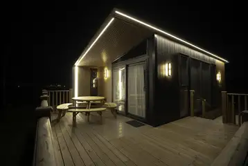 Glamping S-pod lit up at night